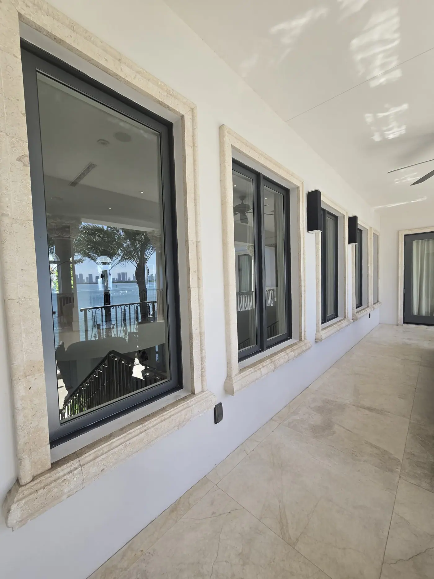 Floor-to-ceiling glass and stone detailing on a luxury waterfront home